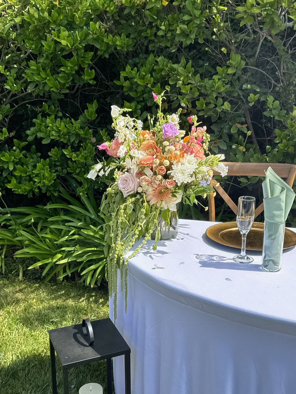 Sweetheart table with a cascading centerpiece at Marie and James's garden wedding